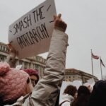 woman holding white paper with smash the pairtarchy